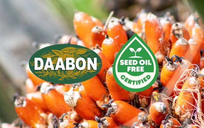 A close-up of fresh red palm fruit with the DAABON logo and the Seed Oil Free Certified seal overlaid.