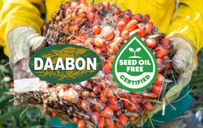 Farmer holding fresh palm fruit bunches representing Daabon’s certified sustainable palm oil, verified under the Seed Oil Free Movement certification.